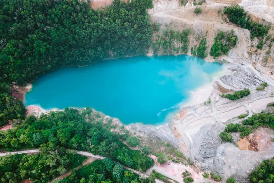 Suasana danau kecil di tengah hutan Papua dengan air biru kehijauan